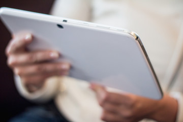woman holds a smartphone telephone, works on the digital tablet, soft focus, close up