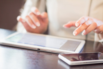 woman holds a smartphone telephone, works on the digital tablet, soft focus, close up