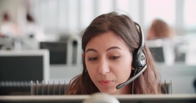 Young woman working in a call centre using a headset