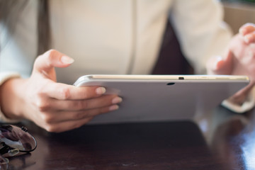 woman holds a smartphone telephone, works on the digital tablet, soft focus, close up