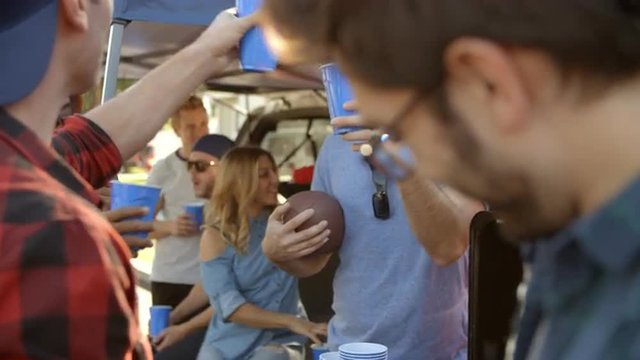 Slow Motion Shot Of Sports Fans Tailgating In Parking Lot