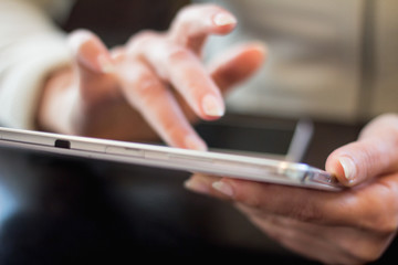 woman holds a smartphone telephone, works on the digital tablet, soft focus, close up