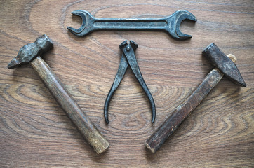 Vintage tools (hammer, wrench, nippers) on wooden background
