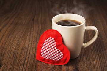 Large cup of hot drink and heart textile on a wooden table. The concept of Valentine's day holiday