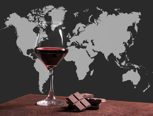 Red wine glass with chocolate and world map