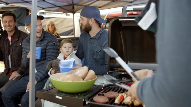 Slow Motion Shot Of Sports Fans Tailgating In Parking Lot