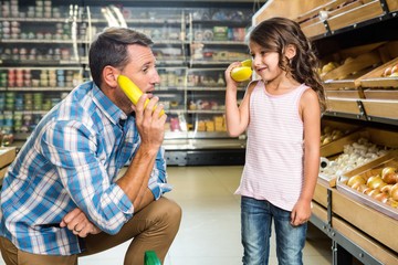Father and daughter playing with bananas