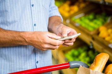 Man texting and grocery shopping