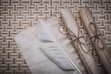 Fototapeta na wymiar Rolls of vintage paper clean sheet feather on wicker mat