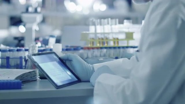 Senior male scientist is using a tablet computer in a laboratory. Shot on RED Cinema Camera.