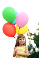 Fototapeta na wymiar Little girl with balloons outside
