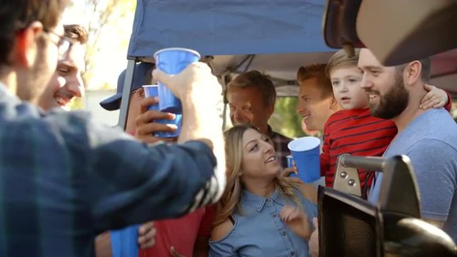 Slow Motion Shot Of Sports Fans Tailgating In Parking Lot