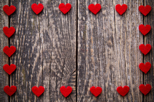 Brown wooden background with red hearts.