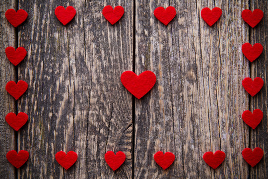 Brown wooden background with red hearts.