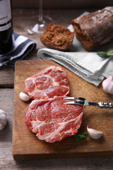 Marbled beef steak with bottle of wine and spices on wooden background