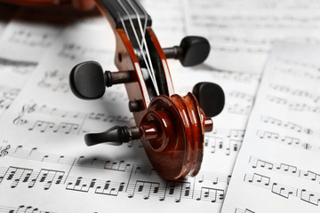 Naklejka premium Violin neck on music papers background