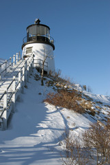 Owls Head Lighthouse on snow covered cliff in Maine.