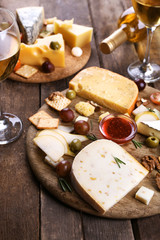 Different kinds of cheese on wooden background