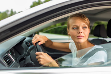 Young woman driving her car, on her way home from work 