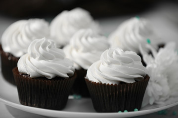 Chocolate cupcakes and flowers on a table