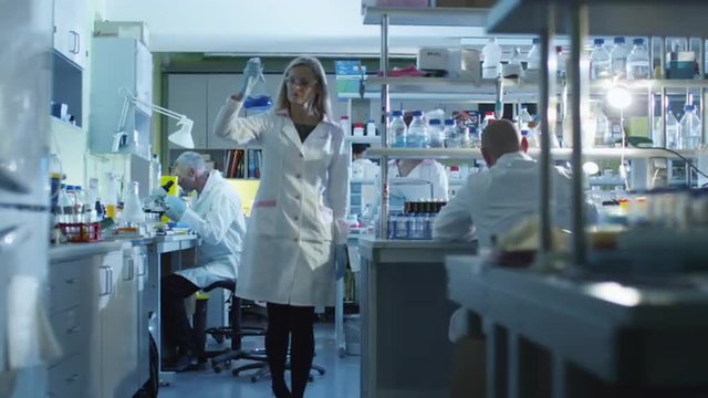 Focusing shot of people working in a modern laboratory Shot on RED Cinema Camera.
