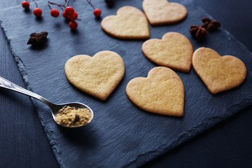 Heart shaped biscuits with ash berries on a mat
