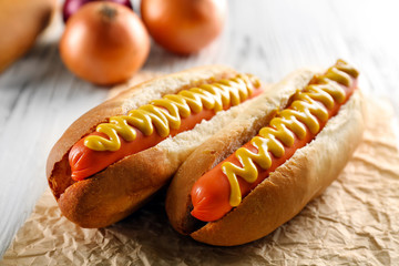 Hot dogs and fresh onions on wooden background