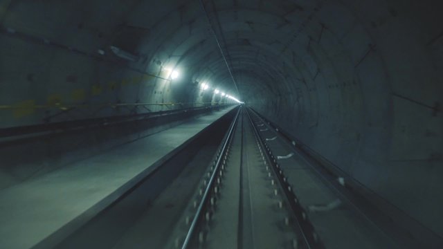 High speed ride of a train in a straight underground tunnel in the modern city