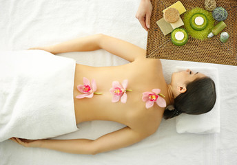 Obraz na płótnie Canvas Spa concept. Woman relaxing with orchids on her back
