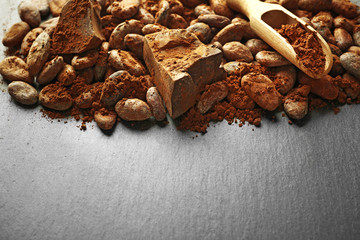 Aromatic cocoa beans and chocolate on grey background, copy space