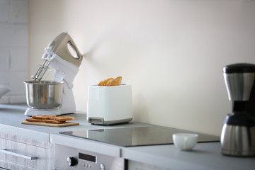 Toaster with coffee maker and mixer on a light kitchen table