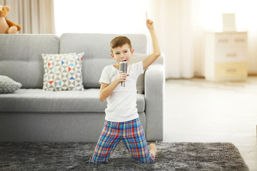 Little boy singing with a microphone at home