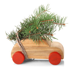 Wooden toy car with fir sprigs, isolated on white