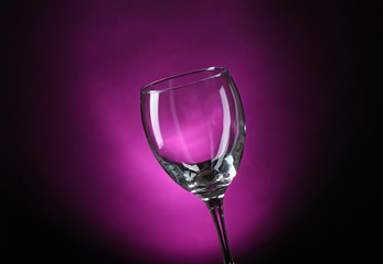 Empty wineglass on dark purple background