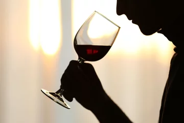 Rolgordijnen Silhouette of man sniffing red wine in a glass, close up © Africa Studio