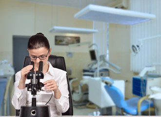 Woman scientist looking through microscope