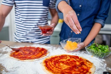 Smiling couple preparing pizza