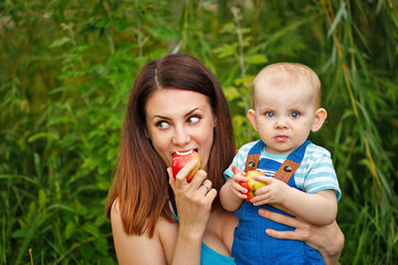 Mother and daughter eating apples.