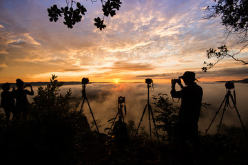 Fototapeta na wymiar silhouette man taking photo of sun rise
