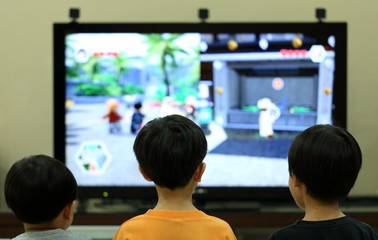 Three Kids Playing Console Game in Front of Television