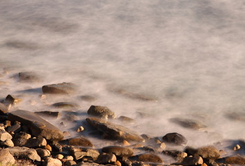 Rocks on beach - Waves washing up on rocks on the beach