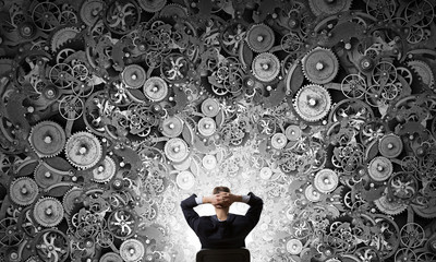 Businessman looking at gear mechanism
