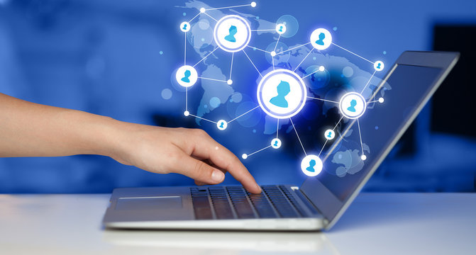 Close up of hand with laptop and social media icons