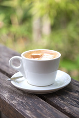 A Cup of coffee on wooden table in the garden