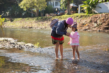 Mother and daughter playing in river