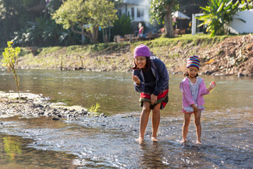 Mother and daughter playing in river