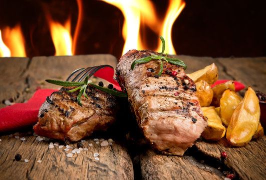 Grilled steaks on wooden table 