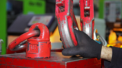 Factory Worker Attaching Crane Hooks to a Heavy Load