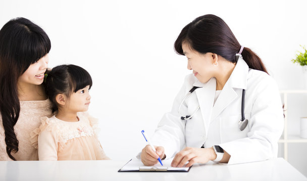 young female doctor talking to  child and mother