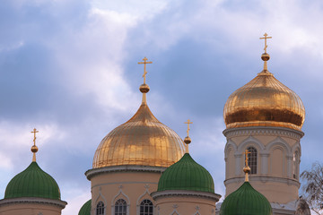 Fototapeta na wymiar Church with gold and green domes against the sky